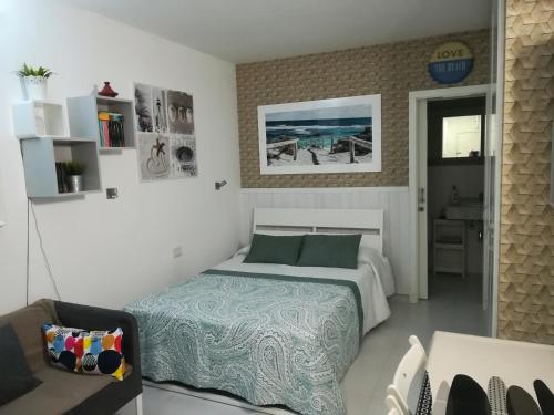 une chambre avec un lit et une chaise dedans dans l'établissement Apartamento Beach Loft Las Canteras, à Las Palmas de Gran Canaria