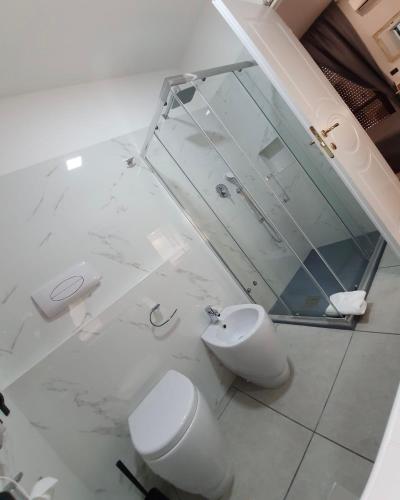 a white bathroom with a toilet and a sink at Guest House Piazza Carmine in Reggio Calabria