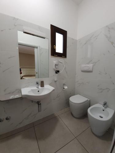 a bathroom with a sink and a toilet and a mirror at Guest House Piazza Carmine in Reggio Calabria