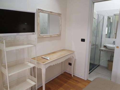 a bathroom with a desk with a tv and a mirror at Guest House Piazza Carmine in Reggio Calabria
