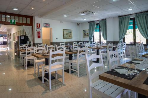 a restaurant with wooden tables and white chairs at Hotel Marina in Sestri Levante