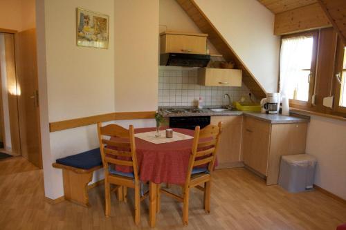 uma cozinha com mesa e cadeiras num quarto em Ferienwohnung em Seelbach