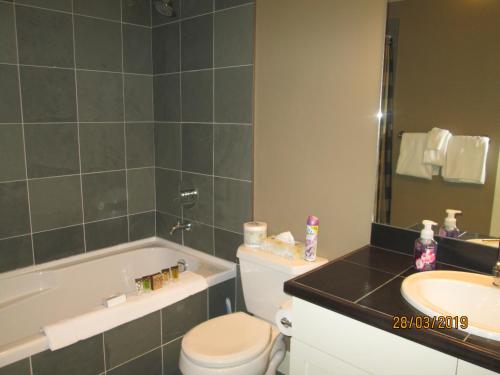 a bathroom with a sink and a toilet and a bath tub at OUTBACK,Lakeside Vacation Home Resort in Vernon