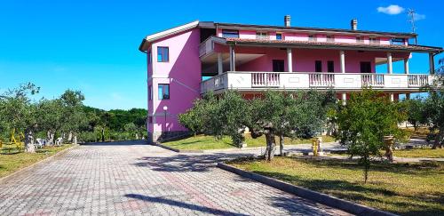 um edifício cor-de-rosa com uma varanda numa rua em Villa Rita - Casa Vista Mare - Vasto Punta Penna em Vasto