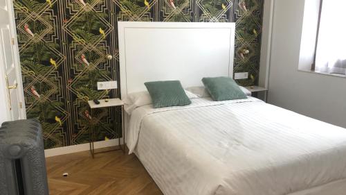 a bedroom with a bed with two green pillows on it at SUITES CASA LUBÉN in León