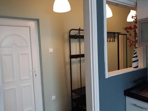 a hallway with a white door and a mirror at HEMNES Apartman in Kaposvár
