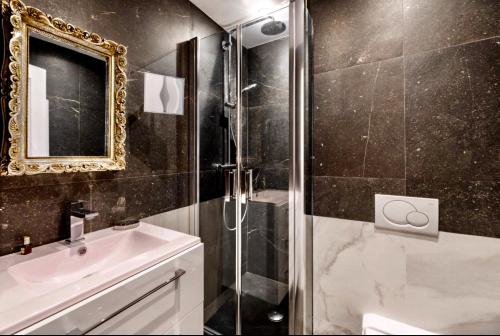 une salle de bain avec une douche, un lavabo et un miroir dans l'établissement La Croisette - Superbe studio au mythique Palais Miramar, à Cannes