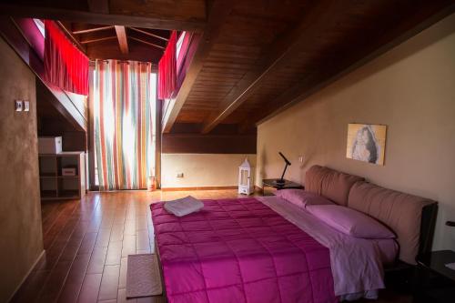 Capri LeoneにあるMansarda in centro al quarto pianoのベッドルーム(紫の毛布を使用した大型ベッド1台付)
