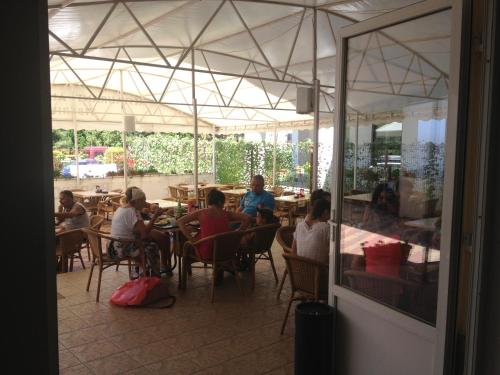 a group of people sitting at tables in a restaurant at Tiberius Residence in Costinesti