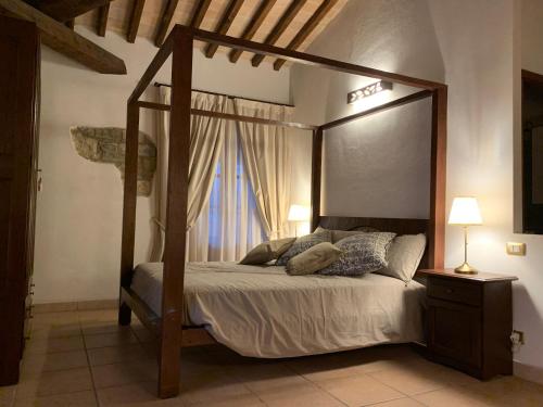 a bedroom with a canopy bed and a window at Villa Le Bolli in Radicondoli