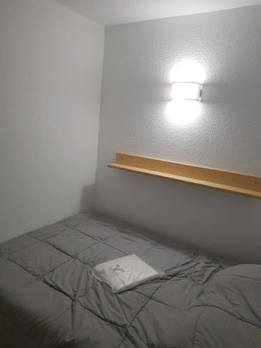 Zimmer mit einem Bett und einer Lampe an der Wand in der Unterkunft Appartement vue Mer in Le Barcarès