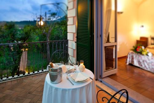 a table with plates and glasses on a balcony at Hotel Villa Rizzo Resort and Spa in San Cipriano Picentino