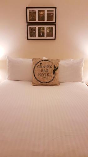 a bed with a pillow sitting on top of it at Grains Bar Hotel in Oldham