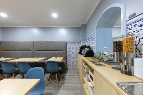 a restaurant with blue walls and wooden tables and blue chairs at D' El Rei B&B in Matosinhos