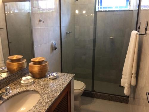 a bathroom with a shower and a sink and a toilet at Bela e Aconchegante Casa em Itaipava in Petrópolis