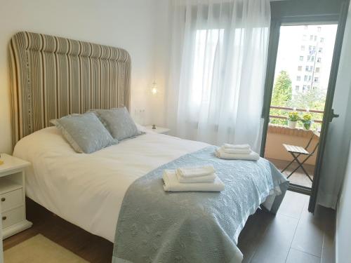 a bedroom with a bed with two towels on it at Fuente Foncalada Oviedo Centro Gascona in Oviedo