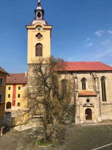 an old church with a tower with a clock on it at Apartmány CAFÉ-CAFÉ in Jičín