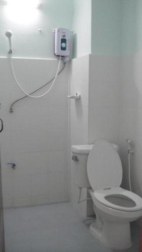 a bathroom with a toilet and a light on the wall at Pakchong Phubade Hotel in Pak Chong