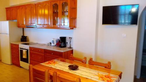 Una cocina con gabinetes de madera y una mesa de madera. en Sea Whispers Beach House, en Alykes