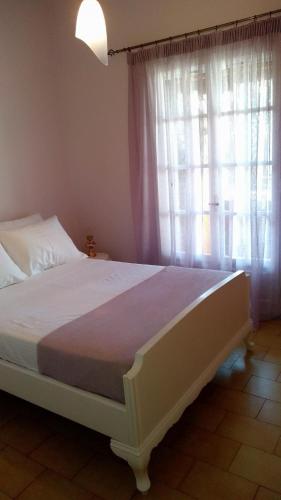 a bedroom with a large bed with a window at Sea Whispers Beach House in Alykes