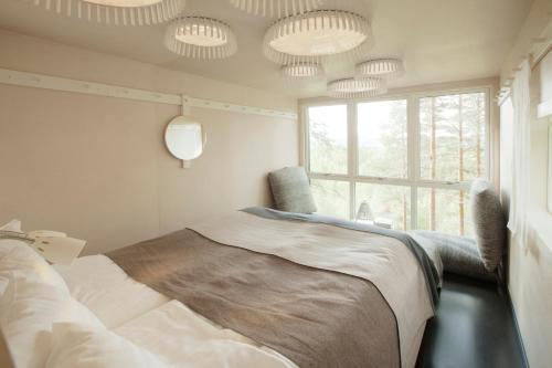 a bedroom with a bed and a window and lights at Treehotel in Harads