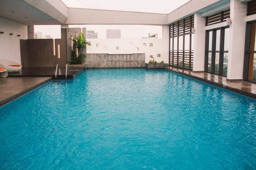 a swimming pool in a building with blue water at WeSanitise PJ5 Soho Studio Room in Petaling Jaya