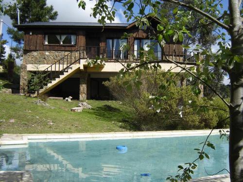 a house with a swimming pool in front of a house at La Martina in Sierra de los Padres