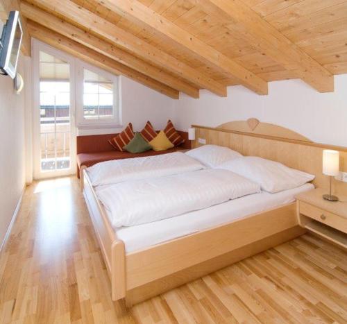 1 cama grande en un dormitorio con techo de madera en Penthouse Kurz, en Westendorf