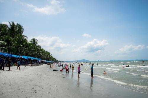 a group of people walking on the beach at The Zleep Chonburi in Chon Buri