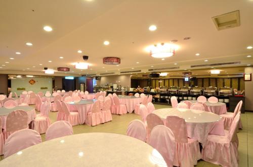 a banquet hall with pink tables and chairs at Ever Delightful Business Hotel in Chiayi City