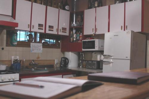 cocina con armarios blancos y nevera blanca en Hostel Rogupani en San Rafael