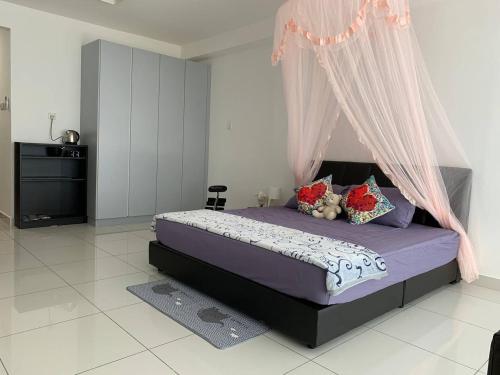 - une chambre avec un lit violet à baldaquin dans l'établissement Offer Spacious Studio KSL Residences Daya, à Johor Bahru