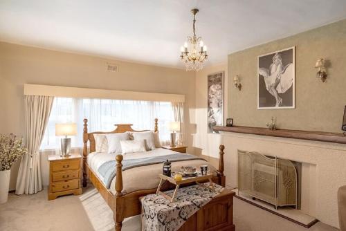 a bedroom with a large bed and a fireplace at Jones On Wilson Boutique B&B in Burnie