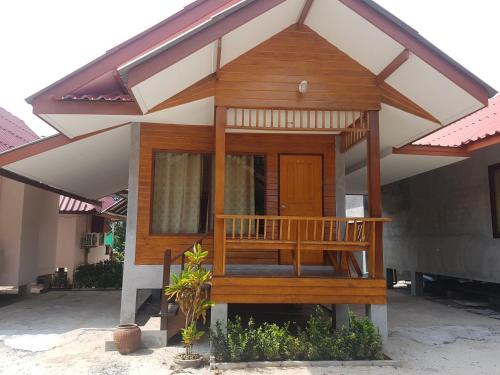 a small house with a porch and a deck at Phuphat Beach Resort in Khanom