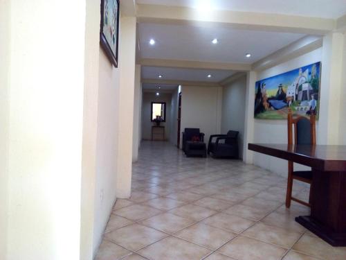 un pasillo en una casa con una mesa y una habitación en Hotel y Bungalows Santa Ana, en Quetzaltenango