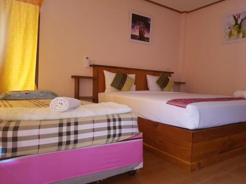 a bedroom with two beds and a window at Phuphat Beach Resort in Khanom