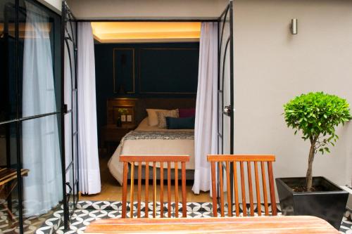 a bedroom with a bed and two chairs at Casa Bis in Mexico City