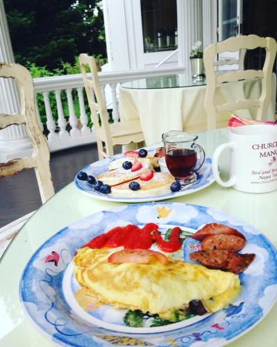 a table with two plates of breakfast food on it at Churchill Manor in Napa