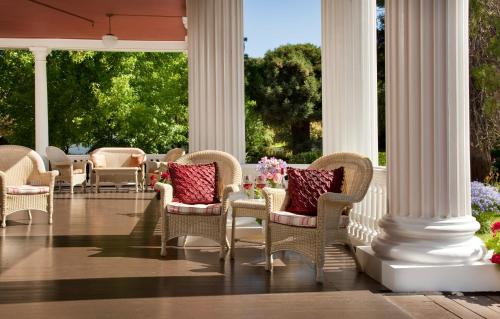 a porch with chairs and pillows and columns at Churchill Manor in Napa