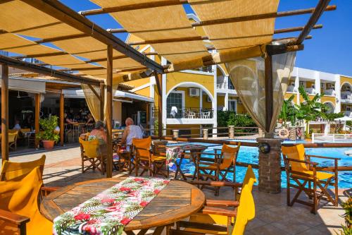 a patio area with tables, chairs and umbrellas at Vanessa Hotel in Kalamaki