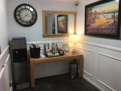 a room with a desk with a clock on the wall at Ocean Lodge Santa Monica Beach Hotel in Los Angeles