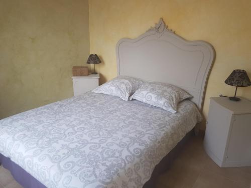une chambre avec un lit blanc avec deux tables de nuit dans l'établissement La Petite Vendeenne, à Brem-sur-Mer
