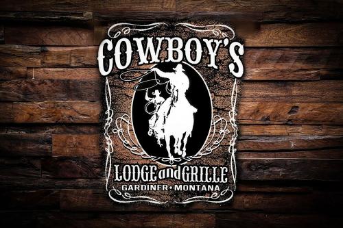 a sign on a wooden wall with a horse and cartridge enforcersmitharma at Cowboy's Lodge in Gardiner