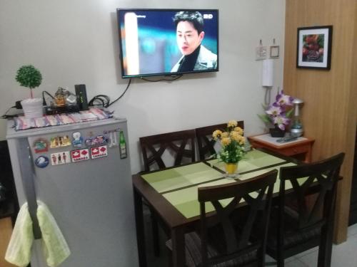 a kitchen with a table and a television on a wall at StayCation Dream CondoTel in Manila