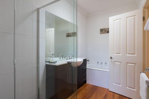 a bathroom with a sink and a glass shower at Healesville Cottage in Healesville