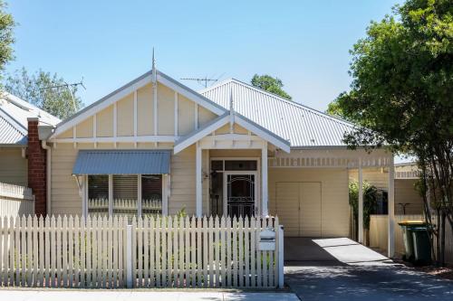 a house with a white fence in front of it at Healesville Cottage in Healesville