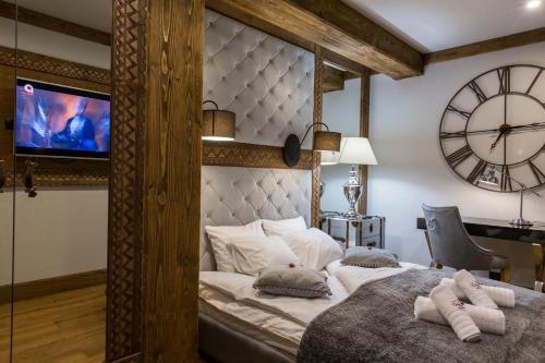ザコパネにあるZakopane FIVE STARSのベッドルーム1室(大型ベッド1台、壁掛け時計付)