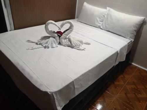two towelcovered swans sitting on top of a bed at The Jungle Container in Quepos