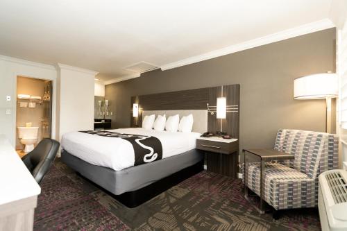 a hotel room with a bed and a chair at Rodeway Inn San Jose HWY-101 Tully Rd Exit in San Jose