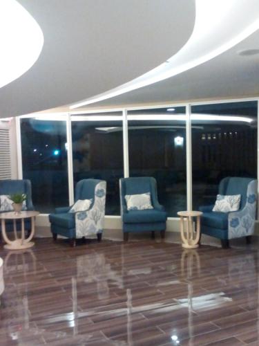 a lobby with blue chairs and tables and windows at StayCation Dream CondoTel in Manila